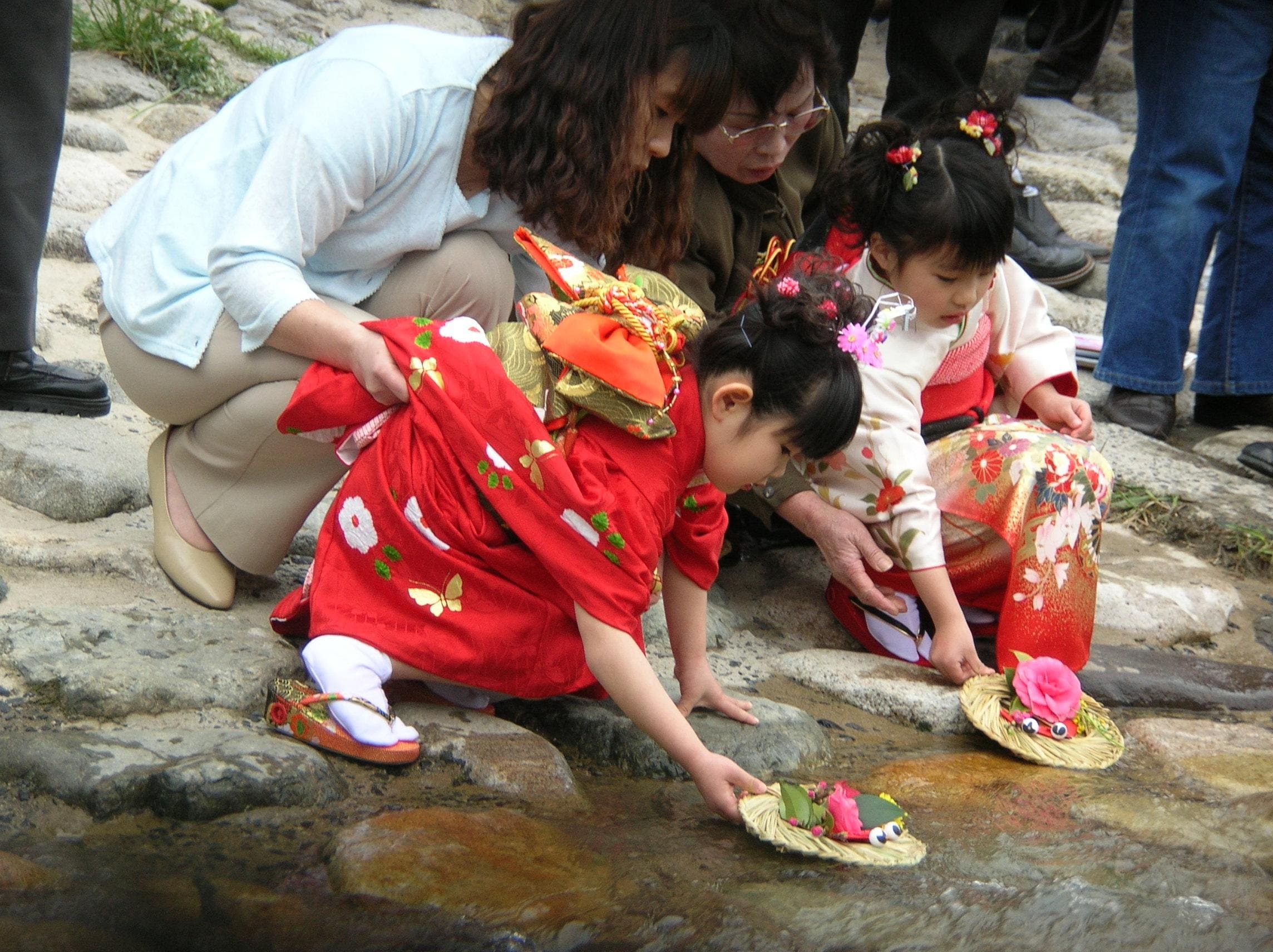 Niñas echando al río las muñecas de papel durante el Hinamatsuri